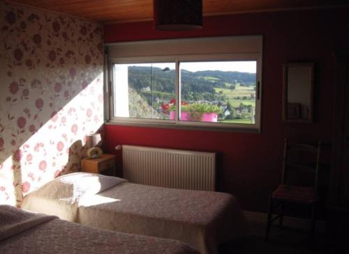 a bedroom with a bed and a window with a view at Les genêts in Saint-Alban-sur-Limagnole