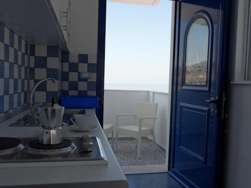 una cucina con lavandino e porta blu di Bouganville Studios Stegna a Archangelos
