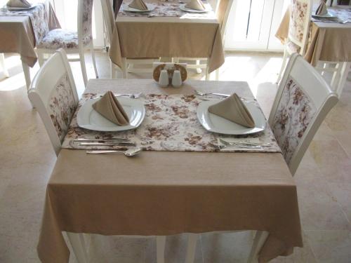 a table with two chairs and a table with plates and napkins at Enda Boutique Hotel Kalkan in Kalkan