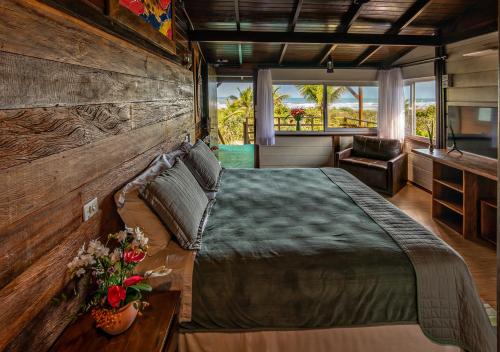 a bedroom with a large bed and a television at Grajagan Surf Resort in Ilha do Mel