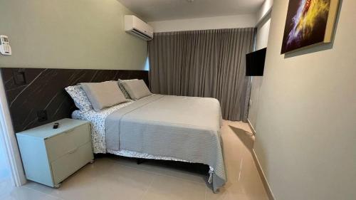 ein kleines Schlafzimmer mit einem Bett und einem Nachttisch in der Unterkunft Apartamento comfortável, ótima localização in Recife