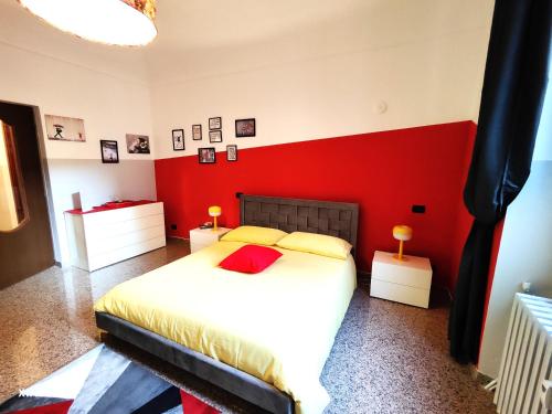 1 dormitorio con 1 cama grande y pared roja en Appartamento Al Novecento Novi, en Novi Ligure