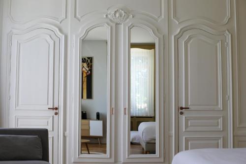 a bedroom with white walls and a mirror at Séquoias Golf & Ressort in Ruy