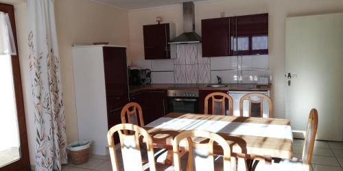 a kitchen with a table and chairs and a refrigerator at Abenteuerhof in Weißenbach