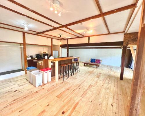 Habitación grande con suelo de madera y bar. en Bathhouse Kasumi - Vacation STAY 25233v en Ina
