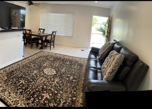 Lovely Single Apartment في لوس أنجلوس: أريكة جلدية سوداء في غرفة معيشة مع طاولة