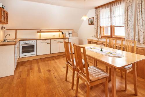 Weißenbach的住宿－Abenteuerhof，厨房以及带木桌和椅子的用餐室。