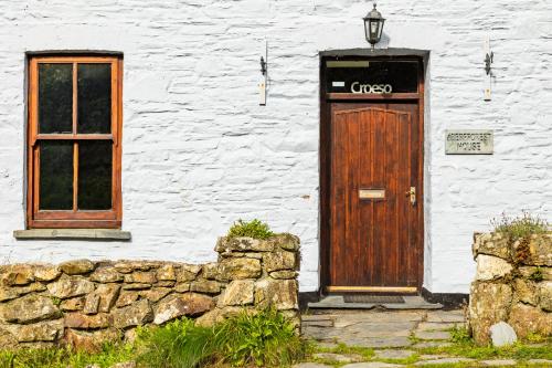 un edificio blanco con puerta de madera y ventana en Aberfforest House, en Newport