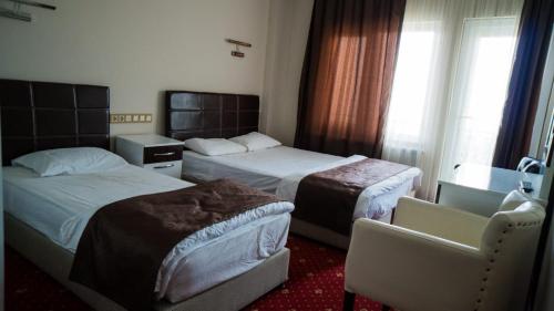 ein Hotelzimmer mit 2 Betten und einem Fenster in der Unterkunft Gürsoy Kampüs Otel in Beysehir