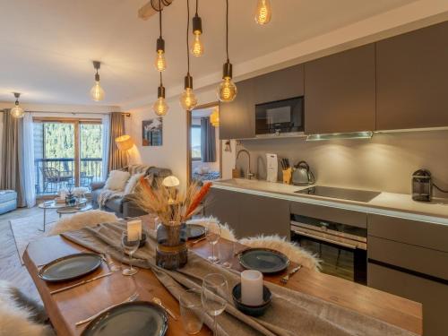 Il comprend une cuisine et un salon avec une table en bois. dans l'établissement Appartement haut standing près des pistes avec parking, WiFi - FR-1-563-128, à Courchevel
