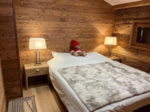 a teddy bear sitting on a bed in a bedroom at Chalet moderne 4 pers avec terrasse, mezzanine et parking - FR-1-505-186 in Crest-Voland