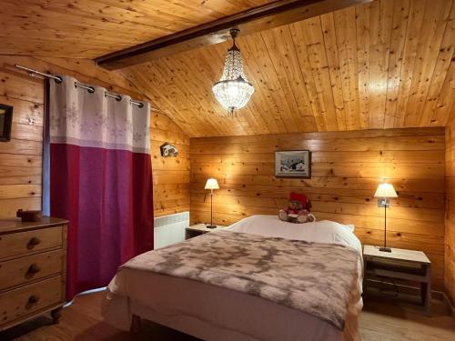 1 dormitorio con 1 cama y pared de madera en Chalet Crest-Voland, 2 pièces, 4 personnes - FR-1-505-187, en Crest-Voland