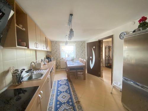 a kitchen with a table and a dining room at Villa Luiza in Şura Mare