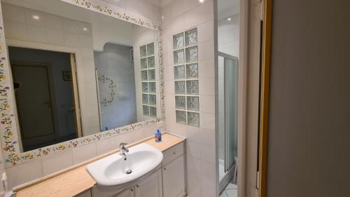 un bagno con lavandino e specchio di A due passi dal mare a Santa Marinella