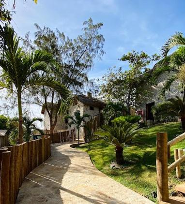 a house with a wooden fence and a walkway at Collina Beach in Amontada
