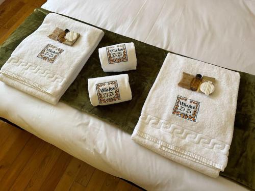ein Bett mit weißen Handtüchern darüber in der Unterkunft Villa Avó Zizi 