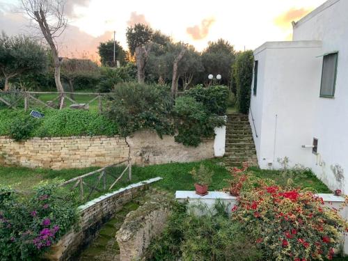 a garden with flowers next to a white building at Baia dei Cesari in Bacoli
