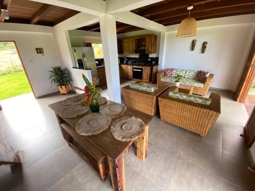 an open living room with a table and chairs at Finca Flor de Maria in Santa Marta