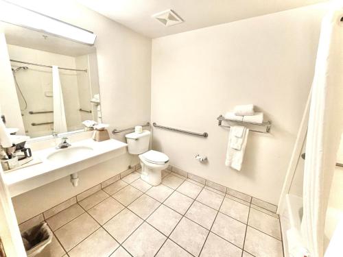 ein Badezimmer mit einem Waschbecken, einem WC und einem Spiegel in der Unterkunft North Shore Inn at Lake Mead in Moapa Valley