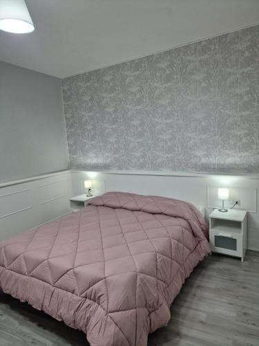 um quarto com uma cama cor-de-rosa e duas mesas-de-cabeceira em Il Corso em Montesarchio