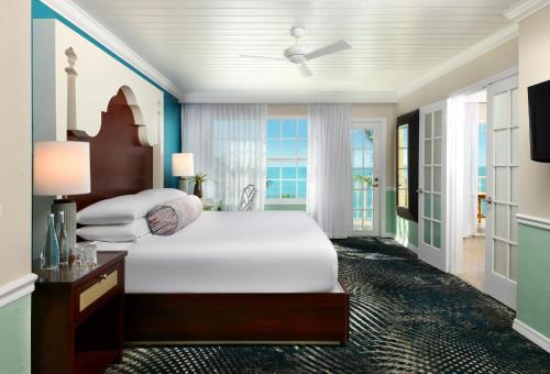 a bedroom with a bed and a large window at Ocean Key Resort & Spa, a Noble House Resort in Key West