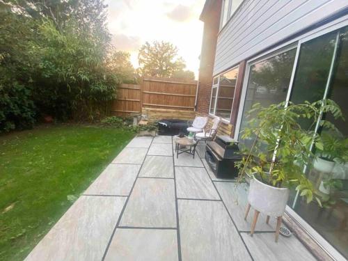 a patio with a chair and a plant in a yard at Pretty fancy staycation - South East London / Kent in Bromley
