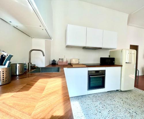 Il comprend une cuisine équipée d'un réfrigérateur blanc et du parquet. dans l'établissement Casa Mandulina - Plein cœur du Quartier Préfecture, à Marseille
