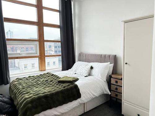 a bedroom with a bed and a large window at Luxury Two Bedroom En-Suité Apartment in Manchester