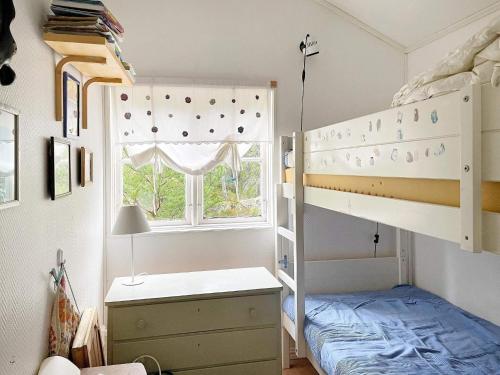 een slaapkamer met een stapelbed en een raam bij Holiday home VÄDDÖ III in Väddö