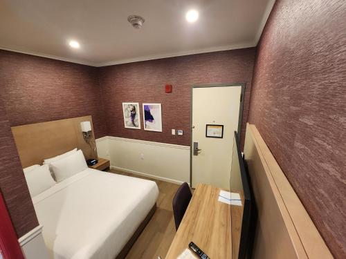 a small room with a bed and a table at The Mayfair Hotel Times Square, an Ascend Collection in New York