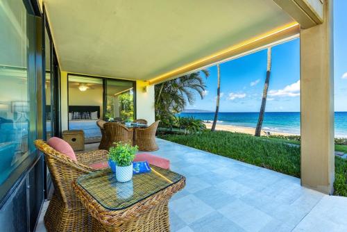 an outdoor patio with a table and chairs and the ocean at Polo Beach Club 106 condo in Wailea