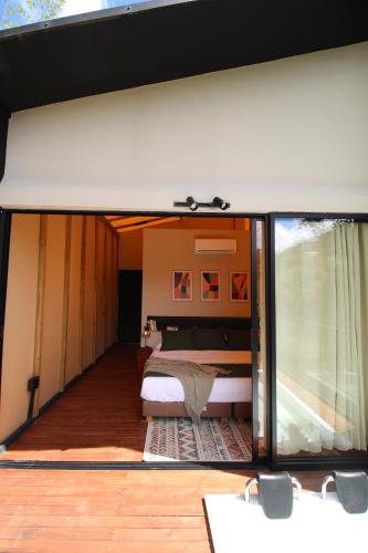 a bedroom is seen through a glass door at Cabañas para parejas cerca a Medellín - LUUM By Roots Rentals in Marinilla