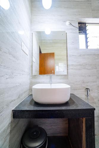 a bathroom with a sink and a mirror at Darsy Residency and beach cottages in Agonda