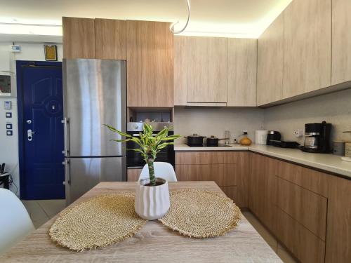a kitchen with a table with a potted plant on it at Sunny Home Private Jacuzzi Hydromassage, Fireplace, Acropolis & Lycabettus View, Underground Parking, 300m Metro Peristeri in Athens