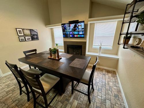 a dining room with a table and chairs and a television at Peaceful West: 4BR Dusk Haven in El Paso