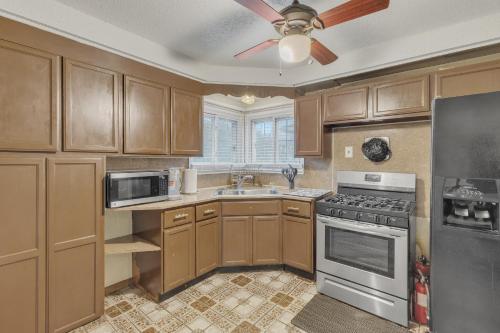 a kitchen with wooden cabinets and a ceiling fan at Cozy 3BR Westland Retreat home in Westland