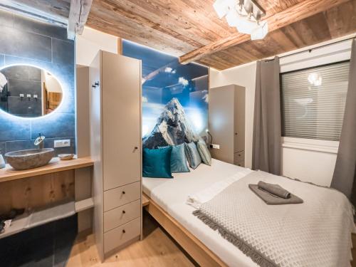 a bedroom with a bed with a mountain mural on the wall at OLDWOOD CHALET - Cozy Alpine Apartment with Balcony in Zillertal, presented by AlpenLuxus in Fügen