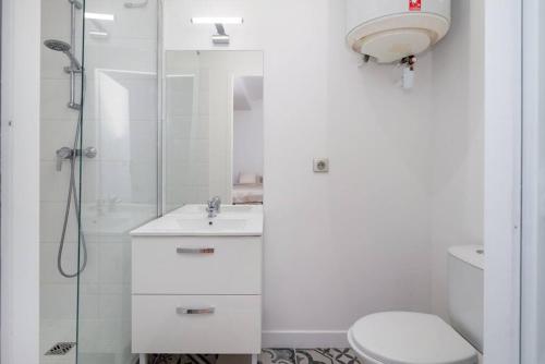a white bathroom with a shower and a toilet at Lumignons Lyonnais - Doua in Villeurbanne