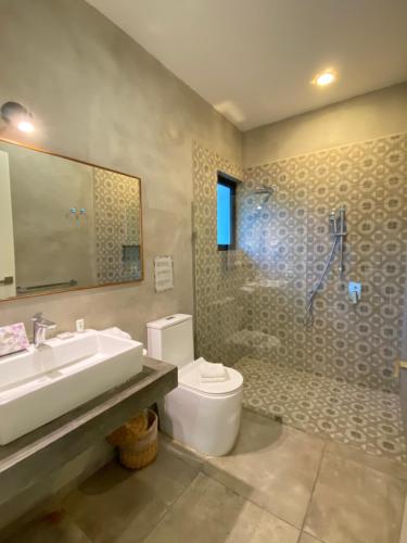 a bathroom with a sink and a toilet and a shower at Panacea Condo Tulum in Tulum