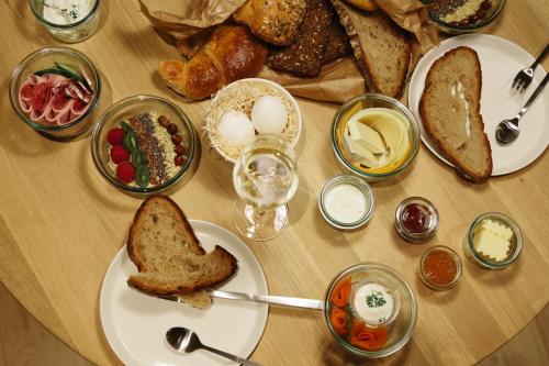 una mesa cubierta con platos de pan y otros alimentos en Mr(s)STiL Design Apartments, en Berlín