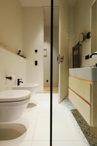 a bathroom with two sinks and a toilet at MrSTiL Design Aparthotel in Berlin