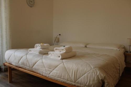a white bed with towels on top of it at Hotel Al Verde in Mandello del Lario