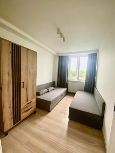 Habitación pequeña con 2 camas y ventana en Apartament Świdnik, en Świdnik