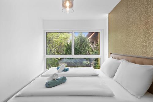a white bed with two pillows and a window at Apartments nähe Schloss Schönbrunn in Vienna