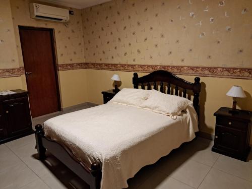 una camera con un letto e due comodini e due lampade di Marcos Paz temporario a San Miguel de Tucumán