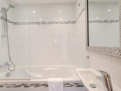 een badkamer met een bad, een wastafel en een spiegel bij Appartement Morzine, 4 pièces, 6 personnes - FR-1-754-23 in Morzine