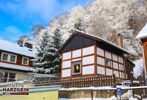 a small house with a window in the snow at Arode Hütte Harzilein - Romantic tiny house on the edge of the forest in Zorge