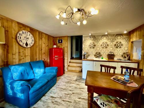 a living room with a blue couch and a red refrigerator at maison la chapelle in Aosta