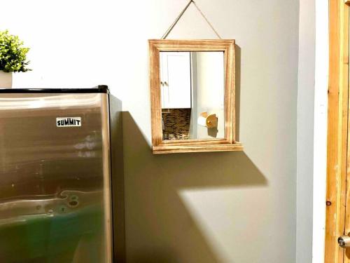 a mirror sitting on a wall next to a refrigerator at Cozy Luxury Studio Staycation - Brooklyn close to Train in Brooklyn
