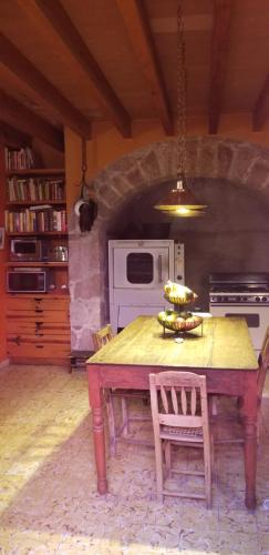 y cocina con mesa de madera, sillas y fogones. en Posada de la Cruz, en Querétaro